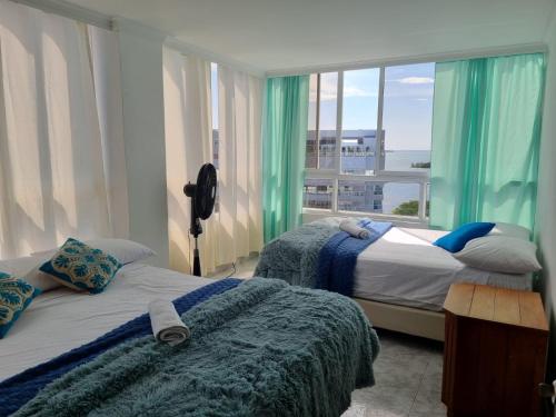 two beds in a room with a large window at Bahía Fragata 803A in San Andrés