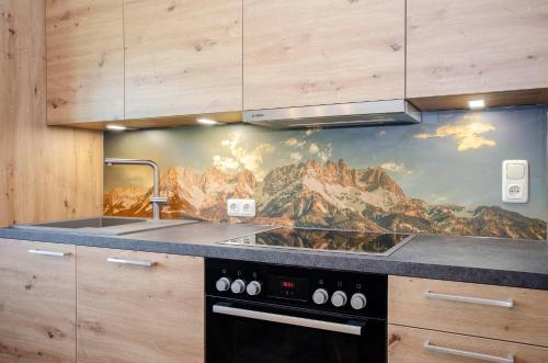 a kitchen with a mountain mural on the wall at Bio-Bauernhof Bachangerhof in Kössen