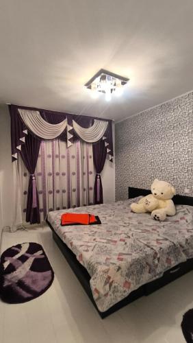 a bedroom with a bed with a teddy bear on it at Planorama Family relax in Bucharest
