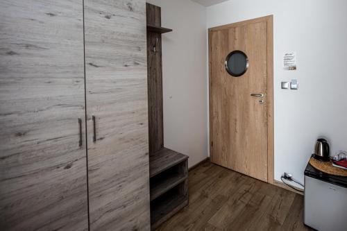 a room with a wooden cabinet and a door at Dom Wypoczynkowy Anna - opcjonalnie śniadania w Starej Piekarni in Kołobrzeg
