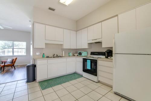 a kitchen with white cabinets and a refrigerator at Explore Dtwn Crystal River Walkable Duplex Unit in Crystal River