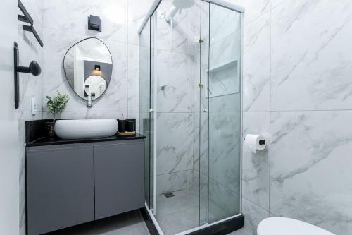 a bathroom with a shower with a sink and a mirror at Studio Completo: Metrô e Aterro do Flamengo in Rio de Janeiro