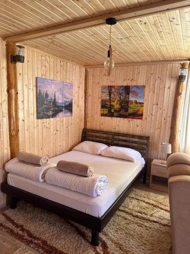 a bedroom with a bed in a room with wooden walls at Vikendice Moskva Uvac in Sjenica