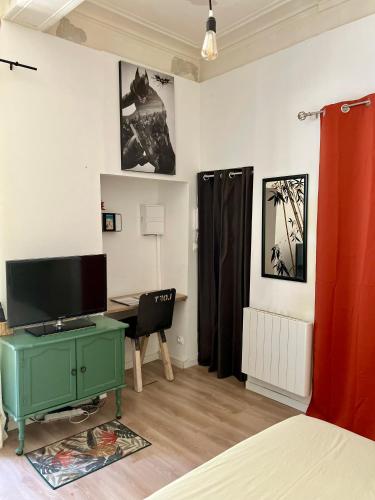 Cette chambre comprend un bureau et un ordinateur. dans l'établissement Studio écusson Nîmois et cour ensoleillée, à Nîmes