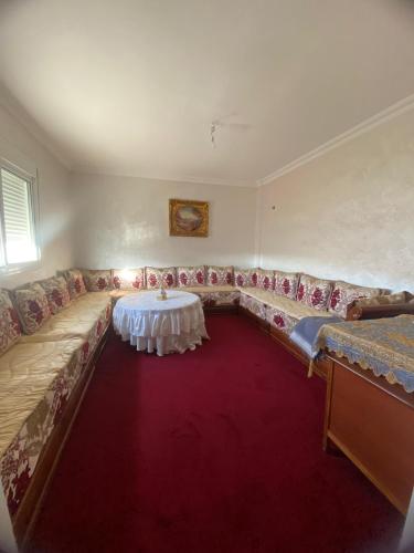 a living room with a couch and a table on a red carpet at شقة جاردينيا - طنجة البالية in Tangier
