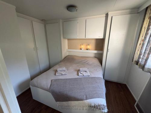 a small bedroom with a bed with two towels on it at ViVe in Putten
