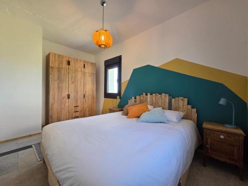 ein Schlafzimmer mit einem großen weißen Bett mit blauem Kopfteil in der Unterkunft A Casa De Margó, casa con encanto en O Grove in San Vicente do Mar