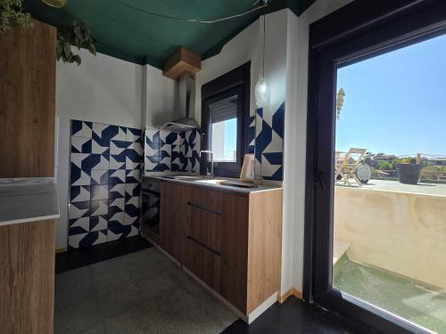 ein Badezimmer mit Waschbecken und großem Fenster in der Unterkunft A Casa De Margó, casa con encanto en O Grove in San Vicente do Mar