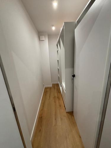 an empty hallway with white walls and wooden floors at Apartament w Twoim Stylu in Zamość