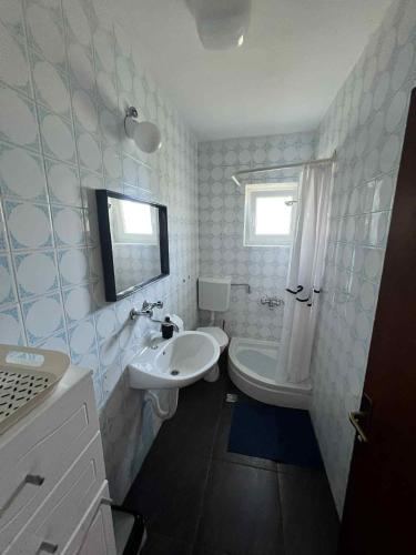 a bathroom with a sink and a toilet and a tub at Rooms Danica in Donji Babin Potok
