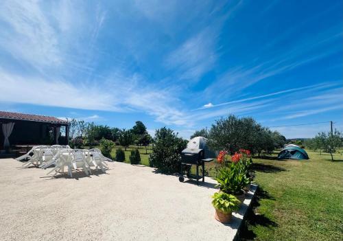 a group of white chairs and a tent at CAMPING LASTE in Smoković