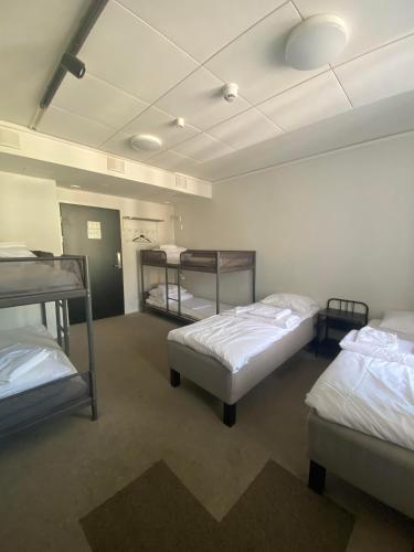 a room with three bunk beds in it at Aikatalo Hostel Helsinki in Helsinki