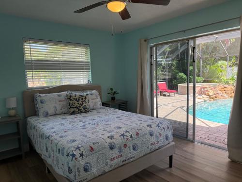 a bedroom with a bed and a sliding glass door at Turtle Cove Beach House in Cape Coral