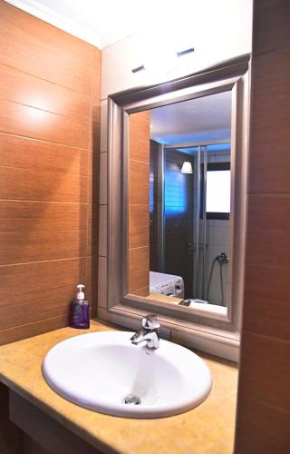 a bathroom sink with a large mirror above it at Stone house Amfikleia in Amfikleia