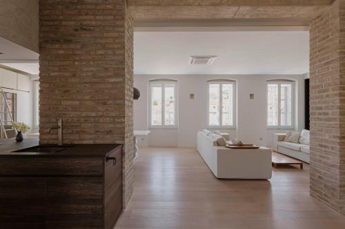 a kitchen and living room with a brick wall at Apartments Argemonia in Mali Lošinj