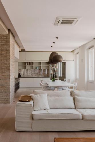 a living room with a white couch and a table at Apartments Argemonia in Mali Lošinj