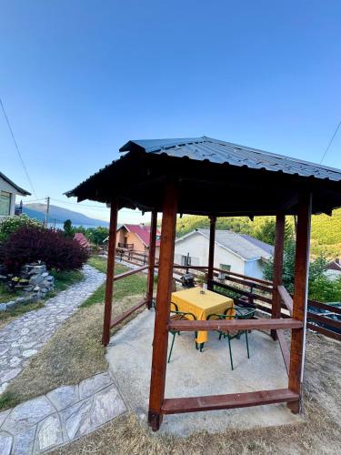 a wooden pavilion with a yellow table in it at Best View Apartment - Mavrovo in Mavrovo