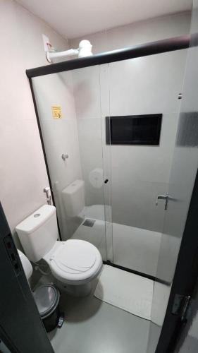 a white bathroom with a toilet and a shower at FLATS CERRADO santa casa in Montes Claros
