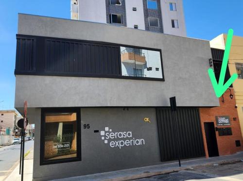 a building with a green arrow pointing to a store at FLATS CERRADO santa casa in Montes Claros