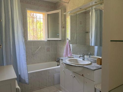 un bagno con lavandino e vasca da bagno di Villa Mireille avec jardin et piscine à Lambesc a Lambesc