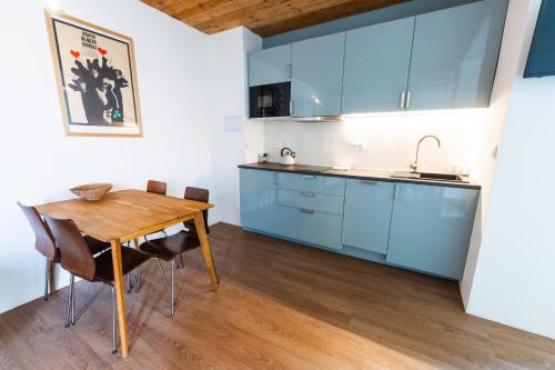 a kitchen with blue cabinets and a wooden table at Pension Merano in Jetřichovice