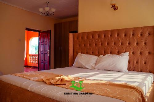 a bedroom with a bed with an orange headboard at Kristina Gardens in Voi