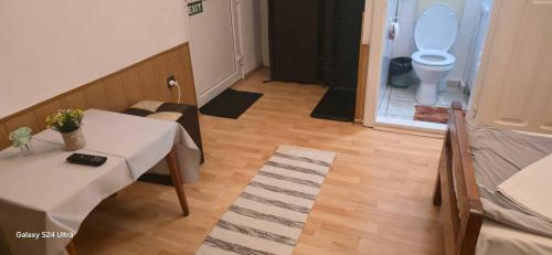 a room with a table and a bathroom with a toilet at Betty Panzio in Miercurea-Ciuc