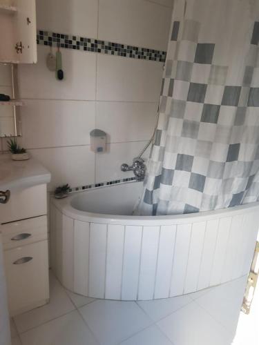 a bath tub with a shower curtain in a bathroom at Ferienhaus an der Nieste in Niestetal