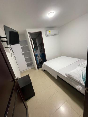 a bedroom with a bed and a flat screen tv at La Noelia in Cali