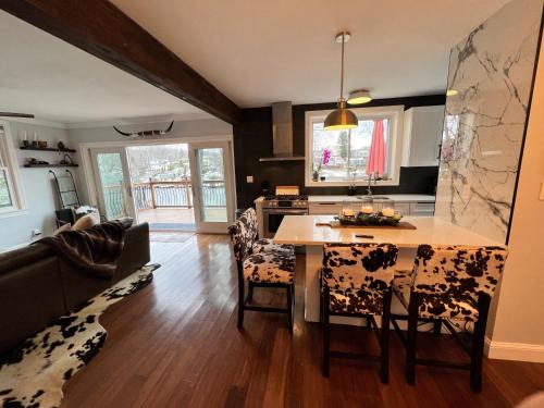 a kitchen and living room with a table and chairs at Cozy Cabin On the Lake with HotTub in Hopatcong