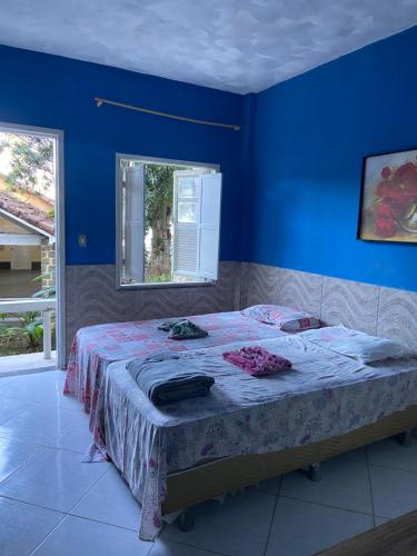 マンガラチバにあるPousada Praia Grandeの青い壁のベッドルーム1室