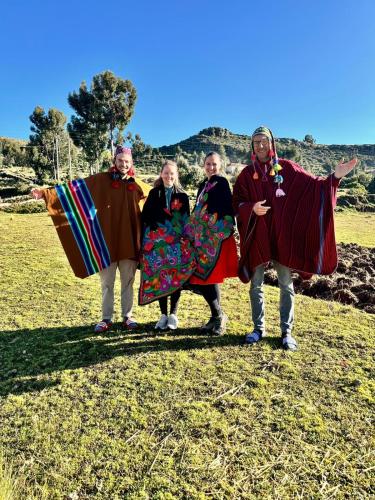 a group of people in costumes standing in a field at Kantuta T'ika Lodge in Isla Amantani