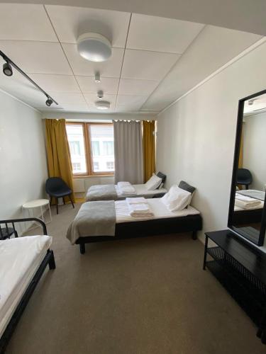 a hotel room with two beds and a mirror at Aikatalo Hostel Helsinki in Helsinki