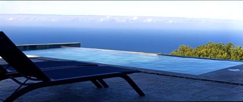 a chair sitting next to a swimming pool at Villa Mahot in Petite Île