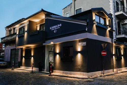 a black building with a sign on the side of it at Karma Chic&Style Intera Villa in Korçë