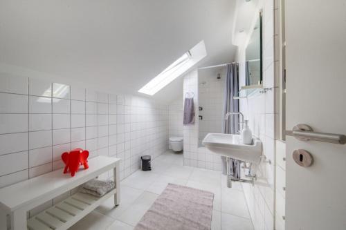 a white bathroom with a sink and a toilet at Gemütliche Ferienwohnung direkt am Wald in Arnsberg