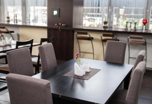 a dining room with a black table and chairs at Old Mill Hotel in Klaipėda
