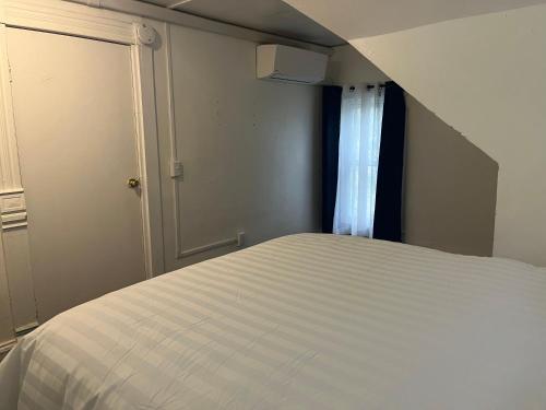 a bedroom with a white bed and a window at Home In Highland Park in Saint Paul