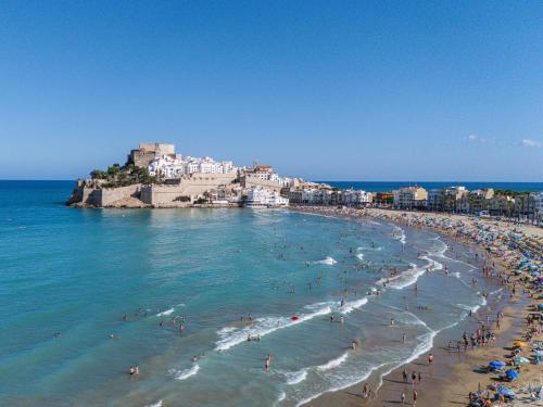 a group of people on a beach in the ocean at Almar Suites in Peñíscola