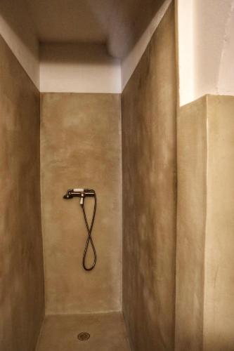 a shower with a hose attached to a wall at Lake View and Sheltered Terrace in Bauduen