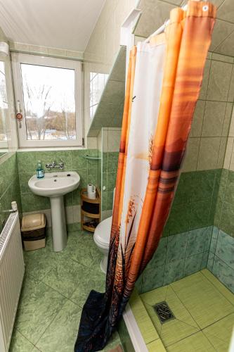 a bathroom with a shower curtain and a sink at Dom Wypoczynkowy Anna - opcjonalnie śniadania w Starej Piekarni in Kołobrzeg