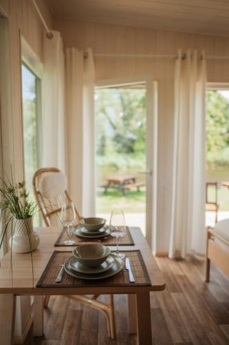 a table with plates and glasses on top of it at Archers island apartment with HOT TUB in Liepāja