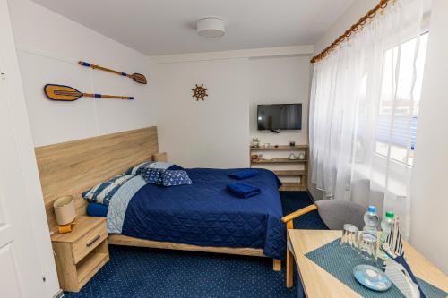 a bedroom with a bed and a desk and a table at Dom Wypoczynkowy Anna - opcjonalnie śniadania w Starej Piekarni in Kołobrzeg