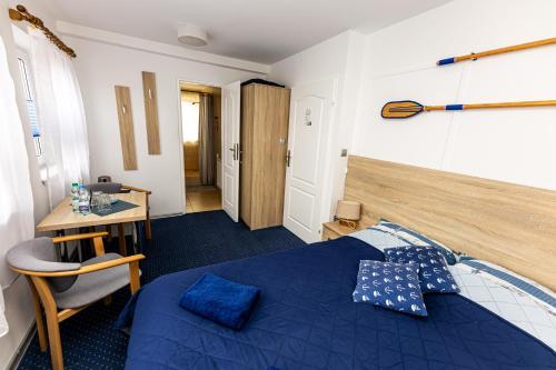 a bedroom with a blue bed and a desk at Dom Wypoczynkowy Anna - opcjonalnie śniadania w Starej Piekarni in Kołobrzeg