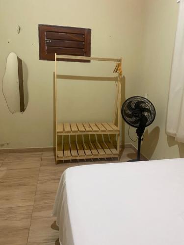 a bedroom with a bed and a fan in a room at Casa em Praia de Flecheiras in Trairi