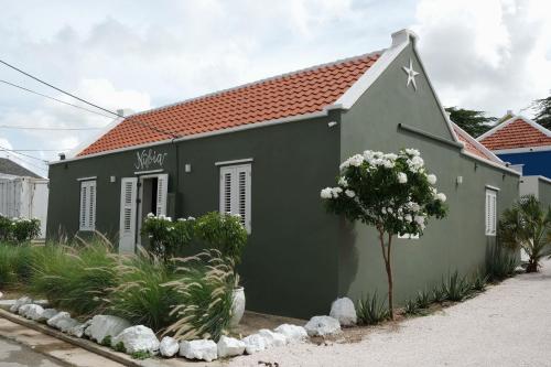un edificio verde con techo rojo en Nubia Suites - Boutique luxury appartments in Otrobanda - UNESCO area, en Willemstad