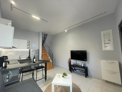 a kitchen and living room with a table and a tv at House of Memories in Nea Chili