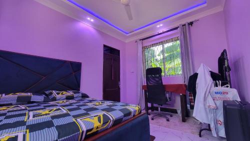 a bedroom with a bed and a purple ceiling at The Village House in Tanga
