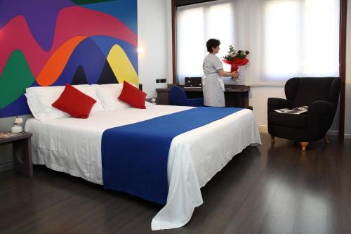 a woman standing in a hotel room with a bed at Hotel Mediolanum in Milan