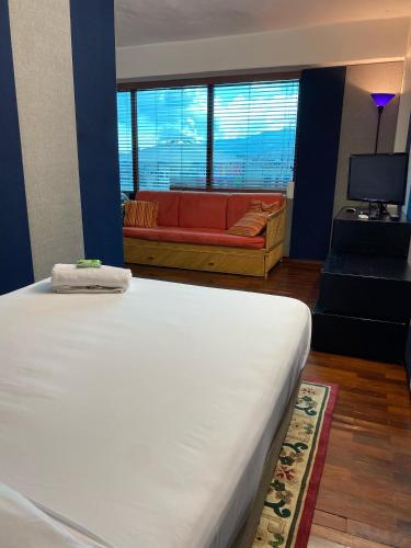 a bedroom with a bed and a couch in a room at Ololó Caracas B&B in Chacao